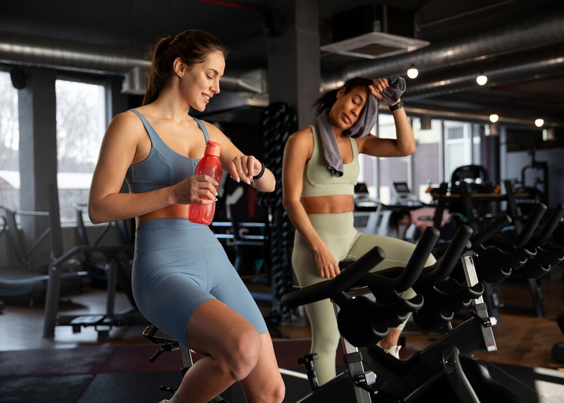 Две девушки занимаются на велотренажере